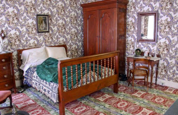Phòng ngủ của phu nhân Mary Lincoln không chỉ là nơi bà nghỉ ngơi, mà còn là nơi bà may vá. Bởi vì tủ quần áo không phải là một nét đặc trưng của phong cách thiết kế nội thất thế kỷ 19, cho nên chiếc tủ đứng cao để quần áo (armoire), và chiếc tủ (closet) của phu nhân Mary rất có thể là một chiếc tủ lớn làm bằng gỗ nguyên khối, chẳng hạn như chiếc tủ hiện đang trưng bày trong phòng ngủ của bà. Bà cũng có một chiếc ghế bập bênh và bàn trang điểm. Giấy dán tường hiện tại trong phòng ngủ của bà là bản sao của phiên bản gốc đã từng tô điểm cho ngôi nhà này. (Ảnh: Được đăng dưới sự cho phép của Cục Công viên Quốc gia)