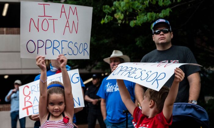 Người dân giơ cao các biểu ngữ trong cuộc tập hợp phản đối thuyết chủng tộc trọng yếu (CRT) đang được giảng dạy trong các trường học tại Trung tâm Chính phủ Quận Loudoun ở Leesburg, Virginia, vào ngày 12/06/2021. (Ảnh: Andrew Caballero-Reynolds/AFP qua Getty Images)