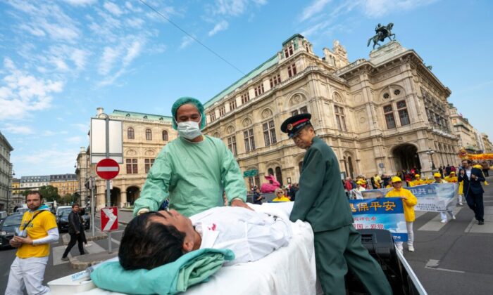 Các học viên Pháp Luân Công ở Vienna, Áo, tái hiện lại một cảnh thu hoạch nội tạng của các học viên bị cầm tù ở Trung Quốc trong một cuộc biểu tình phản đối việc nhập cảng nội tạng người từ Trung Quốc sang Áo, vào ngày 01/10/2018. (Ảnh: Joe Klamar/AFP qua Getty Images)