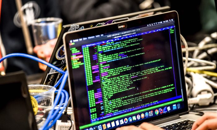 Một người đang chuyển một gói dữ liệu trên một chiếc máy điện toán khi đang làm việc trên máy điện toán xách tay ở Lille, Pháp, trong Diễn đàn An ninh mạng Quốc tế lần thứ 11 vào ngày 22/01/2019. (Ảnh: PHILIPPE HUGUEN/AFP/Getty Images)