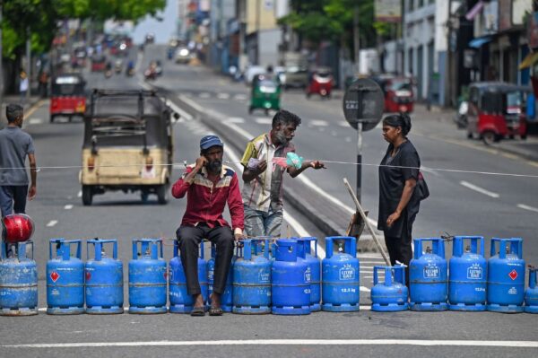 Người tiêu dùng xếp hàng dài để mua gas sinh hoạt sử dụng các bình gas rỗng của họ để chặn một con đường giao lộ chính ở Colombo hôm 08/05/2022, sau khi một cửa hàng địa phương hết nguồn cung. (Ảnh: Ishara S. Kodikara/AFP qua Getty Images)