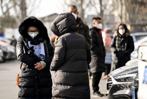 Một người phụ nữ cầm di ảnh của người thân tại một lò hỏa táng ở Bắc Kinh hôm 20/12/2022. (Ảnh: Noel Celis/AFP qua Getty Images)