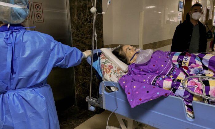 Một bệnh nhân COVID-19 nằm trên băng ca trong khu cấp cứu của Bệnh viện Trực thuộc Số 1 của Đại học Y Trùng Khánh ở thành phố Trùng Khánh phía tây nam Trung Quốc hôm 22/12/2022. (Ảnh: Noel Celis/AFP qua Getty Images)
