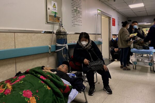 Một bệnh nhân nhiễm COVID-19 nằm trên một chiếc giường kê ở lối đi tại Bệnh viện Công nhân Đường Sơn ở thành phố Đường Sơn, đông bắc Trung Quốc hôm 30/12/2022. (Ảnh: Noel Celis/AFP qua Getty Images)