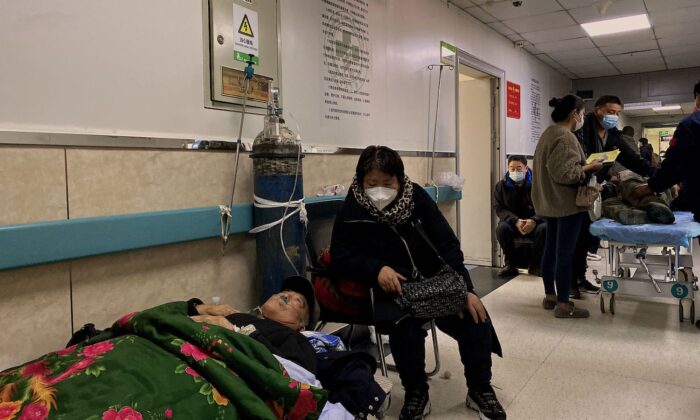 Một bệnh nhân nhiễm COVID-19 nằm trên giường ở hành lang tại Bệnh viện Công nhân Đường Sơn ở thành phố Đường Sơn, đông bắc Trung Quốc hôm 30/12/2022. (Ảnh: Noel Celis/AFP qua Getty Images)