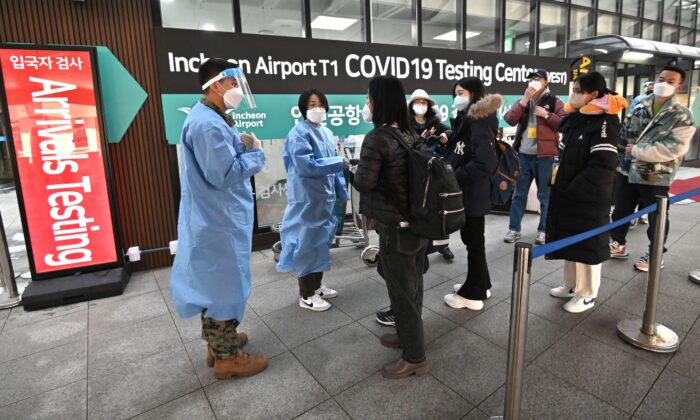 Các nhân viên y tế hướng dẫn các du khách đến từ Trung Quốc trước một trung tâm xét nghiệm COVID-19 tại Phi trường Quốc tế Incheon, phía tây Seoul hôm 03/01/2023. (Ảnh: Jung Yeon-je/AFP qua Getty Images)
