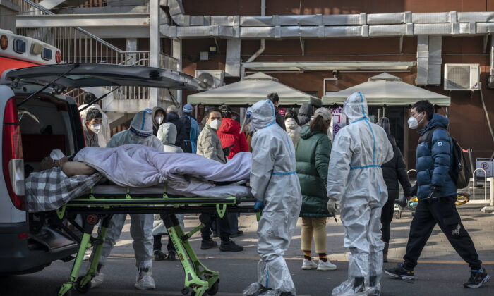 Nhân viên y tế mặc bộ đồ bảo hộ khi đến một phòng khám sốt với một bệnh nhân nằm trên cáng hôm 09/12/2022 tại Bắc Kinh, Trung Quốc. (Ảnh: Kevin Frayer/Getty Images)