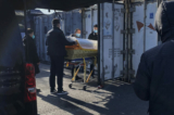 Một linh cữu được hạ từ ​​xe tang và chuyển vào một container bảo quản lạnh tại nhà tang lễ và lò hỏa táng Đông Giao, một trong những nhà hỏa táng trong thành phố được chỉ định để giải quyết các ca nhiễm COVID-19, tại Bắc Kinh hôm 18/12/2022. (Ảnh: Getty Images)