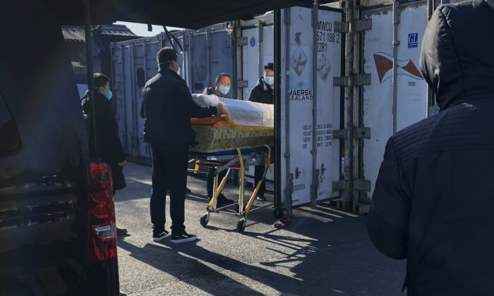 Một linh cữu được dỡ khỏi xe và đưa vào container bảo quản lạnh tại nhà hỏa táng và nhà tang lễ Đông Giao, một trong số những cơ sở được chỉ định tiếp nhận thi thể của những người tử vong vì COVID-19 trong thành phố ở Bắc Kinh, Trung Quốc, hôm 18/12/2022. (Ảnh: Getty Images)