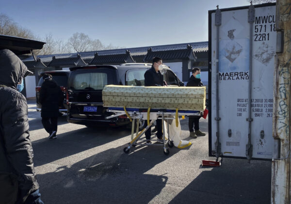 Một linh cữu được hạ xuống từ ​​xe tang để đưa vào một container bảo quản lạnh tại nhà tang lễ và lò hỏa táng Đông Giao, một trong số những lò được chỉ định giải quyết các ca nhiễm COVID-19 của thành phố, ở Bắc Kinh hôm 18/12/2022. (Ảnh: Getty Images)
