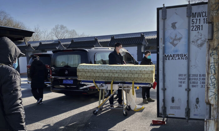 Một linh cữu được hạ từ ​​xe tang vào một container bảo quản lạnh tại nhà tang lễ kiêm nhà hỏa táng Đông Giao, một trong số những địa điểm ở thành phố được chỉ định giải quyết các ca tử vong vì COVID-19, ở Bắc Kinh hôm 18/12/2022. (Ảnh: Getty Images)