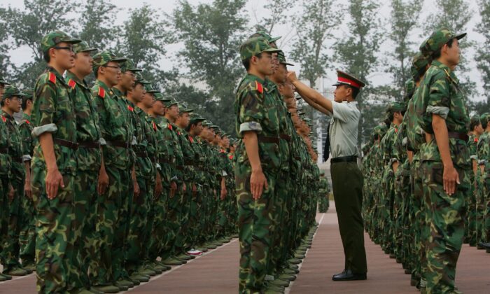 Một sĩ quan quân đội chỉnh lại mũ cho một sinh viên trong khóa huấn luyện quân sự tại Đại học Thanh Hoa ở Bắc Kinh ngày 07/09/2006. (Ảnh: China Photos/Getty Images)
