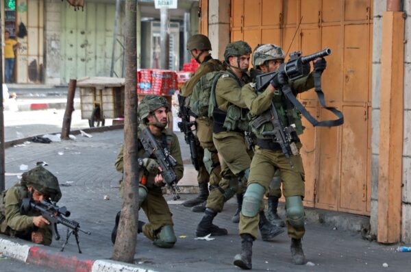 Các binh sĩ quân đội Israel nhắm mục tiêu trong các cuộc đụng độ với người biểu tình Palestine sau một cuộc biểu tình phản đối cuộc “diễn hành cờ” (Flag March) theo chủ nghĩa dân tộc thường niên qua Jerusalem, tại thành phố Hebron ở Bờ Tây bị chiếm đóng hôm 29/05/2022. (Ảnh: Mosab Shawer/AFP qua Getty Images)