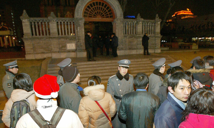 Nhân viên an ninh và cảnh sát Trung Quốc không cho hàng trăm tín đồ Thiên Chúa giáo Trung Quốc vào Nhà thờ Công giáo Vương Phủ Tỉnh trong Thánh lễ Giáng Sinh ở Bắc Kinh, Trung Quốc, vào ngày 25/12/2003. (Ảnh: Goh Chai Hin/AFP qua Getty Images)