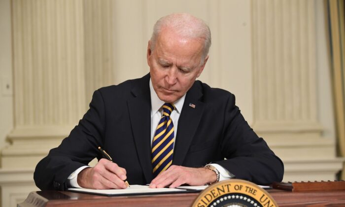 Tổng thống Joe Biden ký sắc lệnh tại Phòng Dạ tiệc Quốc gia của Tòa Bạch Ốc ở Hoa Thịnh Đốn vào ngày 24/02/2021. (Ảnh: Saul Loeb/AFP qua Getty Images)
