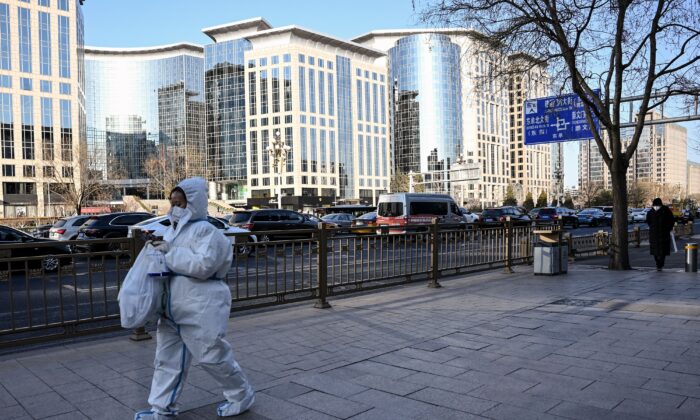 Một phụ nữ mặc đồ bảo hộ cá nhân (PPE) giữa đại dịch COVID-19 đi dọc theo một con phố ở Bắc Kinh hôm 26/12/2022. (Ảnh: Noel Celis/AFP qua Getty Images)