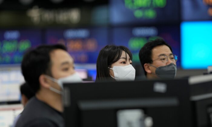 Những người giao dịch tiền tệ đứng gần màn hình hiển thị tỷ giá hối đoái tại một phòng giao dịch ngoại hối ở Seoul, Nam Hàn, hôm 29/12/2022. (Ảnh: Lee Jin-man/AP Photo)