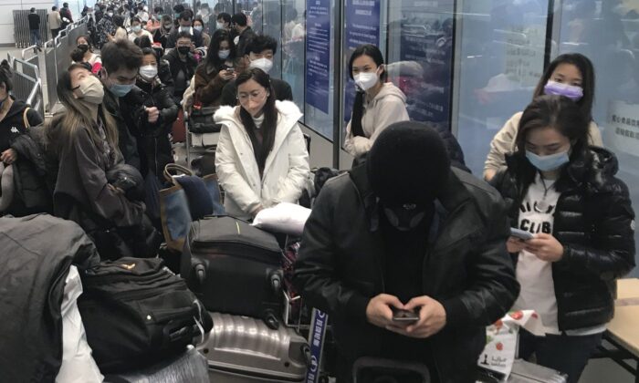 Du khách nội địa chờ đợi hàng giờ để lên xe buýt rời khỏi các khách sạn và cơ sở cách ly từ Phi trường Bạch Vân Quảng Châu ở tỉnh Quảng Đông, miền nam Trung Quốc hôm 25/12/2022. (Ảnh: The Canadian Press/AP, Emily Wang Fujiyama)