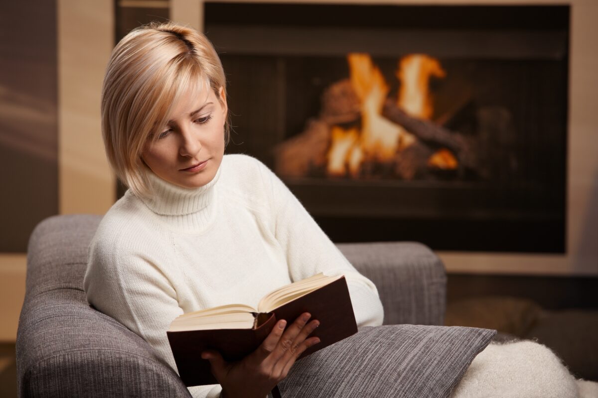 Một lối thoát lành mạnh có thể đơn giản như việc dành một giờ để đọc một cuốn sách thú vị bên lò sưởi. (Ảnh: StockLite/Shutterstock)