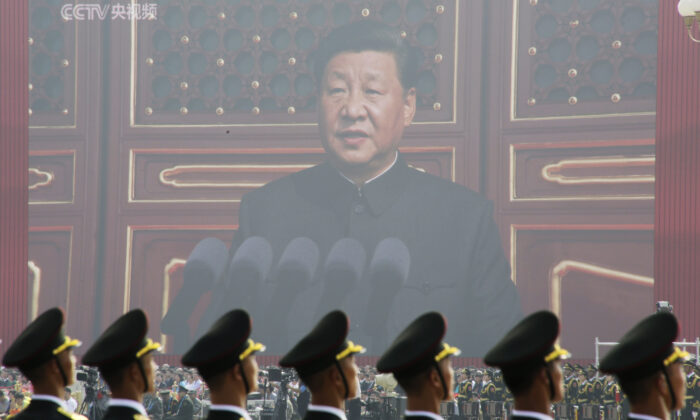 Các binh sĩ Quân Giải phóng Nhân dân đứng trước một màn hình lớn khi lãnh đạo Trung Quốc Tập Cận Bình trình bày tại cuộc duyệt binh kỷ niệm 70 năm thành lập chính quyền ở Bắc Kinh vào ngày 01/10/2019. (Ảnh: Jason Lee/Reuters)