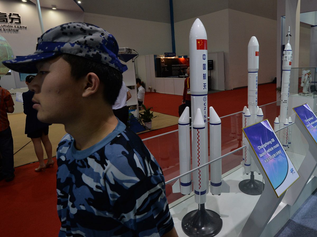 Một nhân viên an ninh đứng cạnh các mô hình tên lửa Trung Quốc được trưng bày tại Bắc Kinh vào ngày 24/09/2013. Chính quyền Trung Quốc đang thử nghiệm các loại vũ khí có thể sớm gây nguy hiểm cho các vệ tinh trên mọi quỹ đạo. (Ảnh: Mark Ralston/AFP/Getty Images)