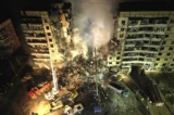 Các nhân viên cứu trợ khẩn cấp dọn dẹp tàn dư sau khi một hỏa tiễn Nga bắn trúng một tòa nhà cao tầng khiến nhiều người mắc kẹt dưới đống đổ nát ở thành phố Dnipro, miền đông nam Ukraine, hôm 14/01/2023. (Ảnh: Evgeniy Maloletka/AP Photo)