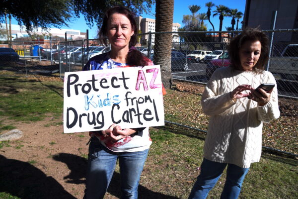Nhân viên cấp cứu và chăm sóc y tế Carley Morgan cầm một tấm biển phản đối các băng đảng ma túy Mexico tại một cuộc họp báo về cuộc khủng hoảng biên giới ở Phoenix, hôm 26/01/2023. (Ảnh: Allan Stein/The Epoch Times)