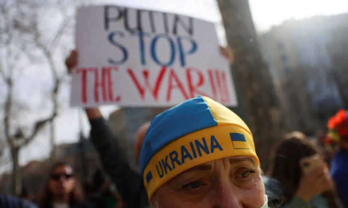 Một người biểu tình đội mũ có hình quốc kỳ Ukraine trong cuộc biểu tình phản đối chiến tranh trước trụ sở Liên minh  u Châu, ở Barcelona, Tây Ban Nha, hôm 24/02/2022. (Ảnh: Nacho Doce/Reuters)