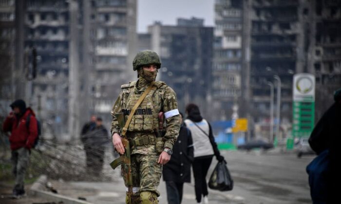 Một người lính Nga tuần tra trên một con đường ở Mariupol, Ukraine, vào ngày 12/04/2022. (Ảnh: Alexander Nemenov/AFP qua Getty Images)