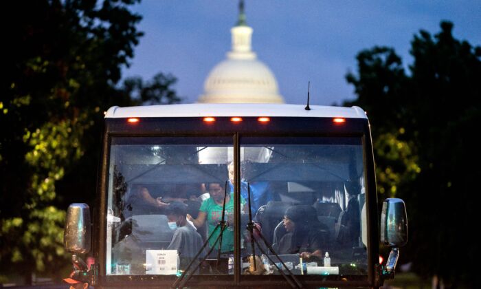 Những người nhập cư bất hợp pháp khởi hành từ một chuyến xe buýt ở Texas được thả xuống tại một địa điểm có thể nhìn thấy được từ tòa nhà Quốc hội Hoa Kỳ ở thủ đô Hoa Thịnh Đốn hôm 11/08/2022. (Ảnh: Stefani Reynolds/AFP qua Getty Images)