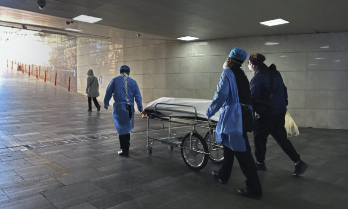 Các nhân viên của bệnh viện và người thân đẩy một thi thể trên băng ca ra khỏi phòng cấp cứu bận rộn tại một bệnh viện ở Bắc Kinh, Trung Quốc, hôm 02/01/2023. (Ảnh: Getty Images)