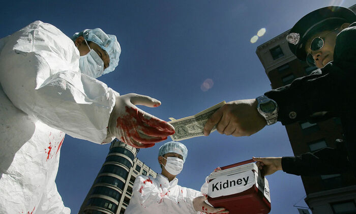 Các học viên Pháp Luân Công mô phỏng cảnh mua bán nội tạng người bất hợp pháp trong một cuộc biểu tình vào ngày 19/04/2006, tại Hoa Thịnh Đốn, nhân chuyến thăm của Chủ tịch Trung Quốc Hồ Cẩm Đào tới Hoa Kỳ. (Ảnh: Jim Watson/AFP qua Getty Images)