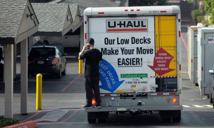 Một người đang nói chuyện qua điện thoại di động khi đang đứng phía sau một chiếc xe tải đang di chuyển ở Pacifica, California, vào ngày 26/01/2016. (Ảnh: Josh Edelson/AFP qua Getty Images)