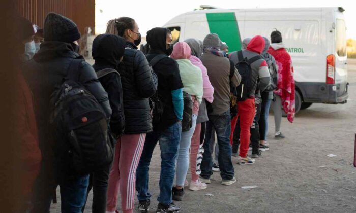 Những người ngoại quốc vượt biên bất hợp pháp xếp hàng xin tị nạn để được các nhân viên Hải quan và Biên phòng Hoa Kỳ giải quyết tại một khoảng trống trên hàng rào biên giới Hoa Kỳ-Mexico gần San Luis, Arizona, vào ngày 26/12/2022. (Ảnh: Rebecca Noble/AFP qua Getty Images)