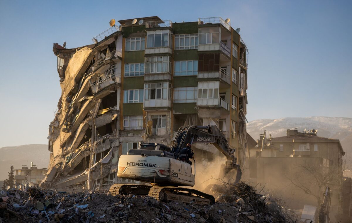 Một chiếc máy xúc làm việc bên cạnh một tòa nhà bị hư hại sau trận động đất gây thương vong ở Kahramanmaras, Thổ Nhĩ Kỳ, hôm 17/02/2023. (Ảnh: Maxim Shemetov/Reuters)