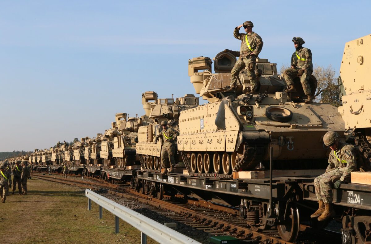 Các thành viên Tiểu đoàn 1 thuộc Sư đoàn 1, Trung đoàn 9 của Lục quân Hoa Kỳ đang tháo dỡ các thiết bị chiến đấu hạng nặng, gồm xe tăng Abrams và xe chiến đấu Bradley, tại nhà ga đường sắt gần căn cứ quân sự Pabrade ở Lithuania vào ngày 21/10/2019. (Ảnh: Petras Malukas/AFP/Getty Images)