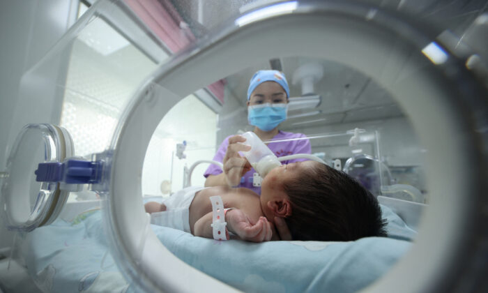 Một nhân viên y tế cho em bé bú tại một bệnh viện ở Đan Trại, tỉnh Quý Châu, tây nam Trung Quốc, vào ngày 11/05/2021. (Ảnh: STR/AFP qua Getty Images)