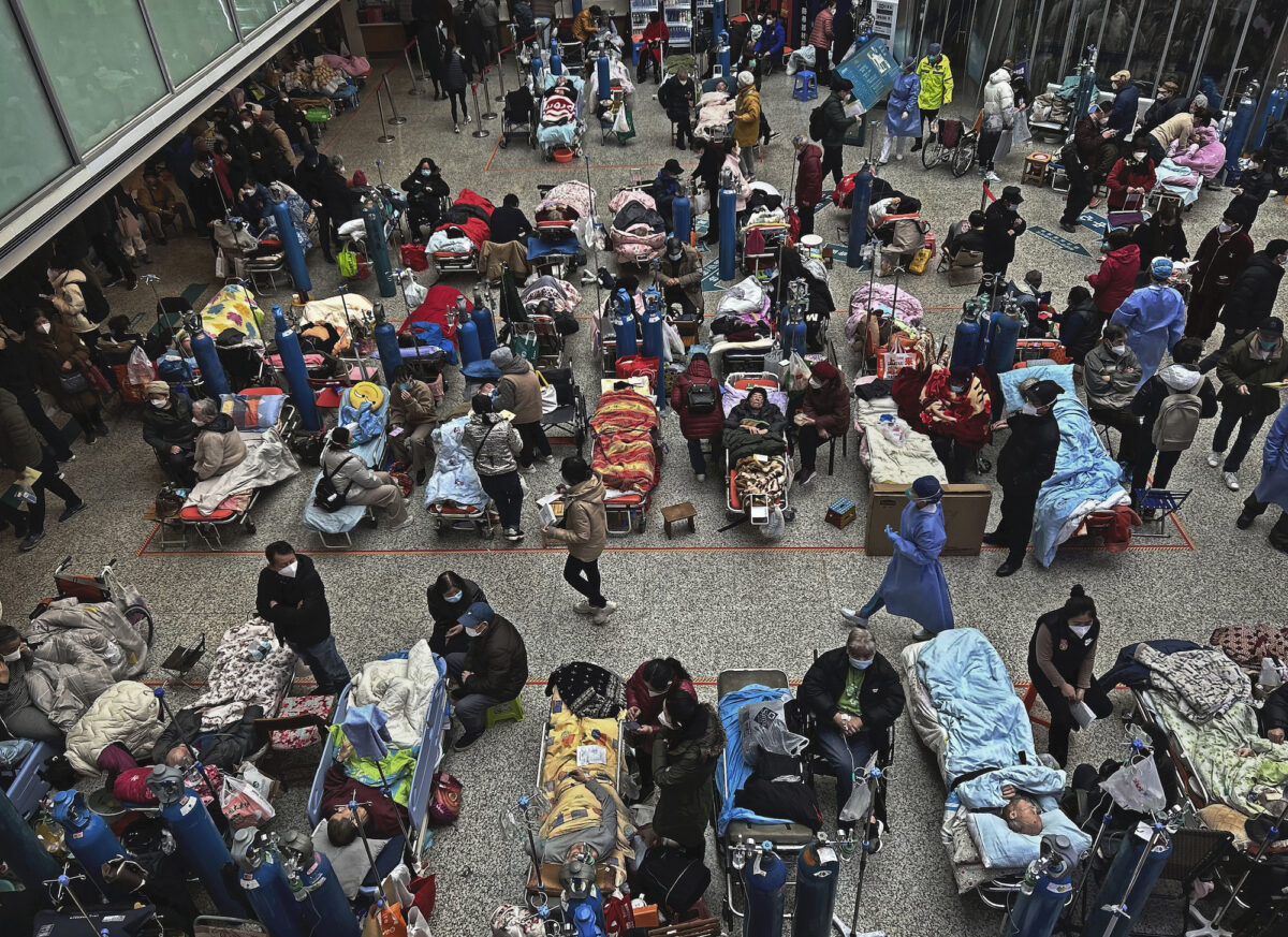 Bệnh nhân được thân nhân và nhân viên y tế chăm sóc khi họ nằm trên những chiếc giường được bố trí ở khu vực sảnh trung tâm của một bệnh viện đông đúc ở Thượng Hải, Trung Quốc, hôm 13/01/2023. (Ảnh: Kevin Frayer/Getty Images)
