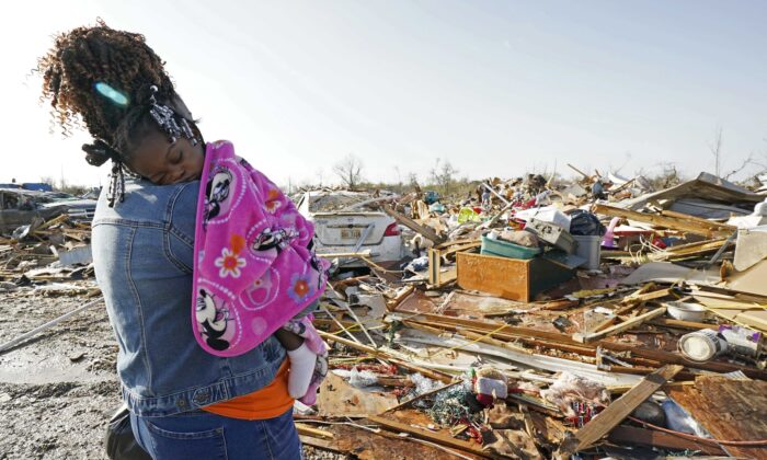 Bà Wonder Bolden bế cháu gái nhỏ 1 tuổi Journey Bolden của mình khi bà xem xét phần còn lại của ngôi nhà di động bị lốc xoáy phá hủy của mẹ bà ở Rolling Fork, Mississippi, hôm 25/03/2023. (Ảnh: Rogelio V. Solis/AP Photo)