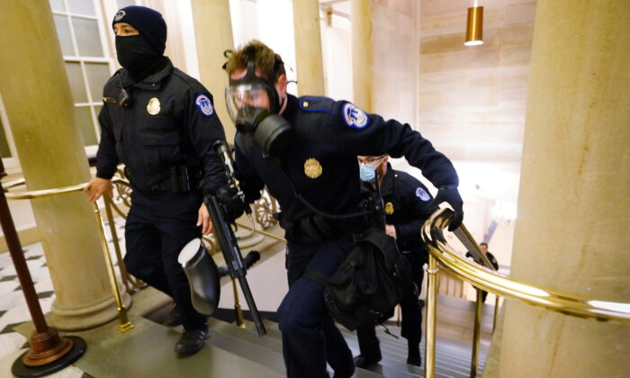 Các sĩ quan cảnh sát Capitol Hoa Kỳ tiến vào vị trí khi những kẻ bạo loạn bước vào tòa nhà Capitol trong một phiên họp chung của Quốc hội tại Hoa Thịnh Đốn hôm 06/01/2021. (Ảnh: Kevin Dietsch/Pool thông qua Reuters)