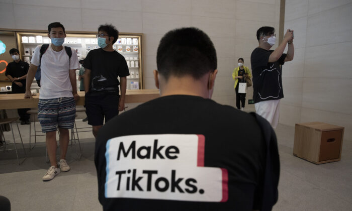 Một người đàn ông mặc một chiếc áo thun in dòng quảng cáo TikTok tại một cửa hàng Apple ở Bắc Kinh, Trung Quốc, vào ngày 17/07/2020. (Ảnh: Ng Han Guan/AP Photo)