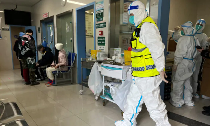 Một nhân viên an ninh trong trang phục bảo hộ theo dõi các nhân viên y tế chăm sóc bệnh nhân tại khoa sốt của Bệnh viện Đồng Tể, cơ sở chính dành cho bệnh nhân COVID-19, ở Vũ Hán, tỉnh Hồ Bắc, Trung Quốc, hôm 01/01/2023. (Ảnh: Reuters)
