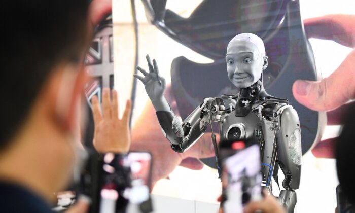 Những người tham dự chụp hình và tương tác với robot hình người có trí thông minh nhân tạo Engineered Arts Ameca khi robot này được đưa ra trình diễn trong Triển lãm Điện tử Tiêu dùng (CES) ở Las Vegas, Nevada, hôm 05/01/2022. (Ảnh: Patrick T. Fallon/AFP qua Getty Images)