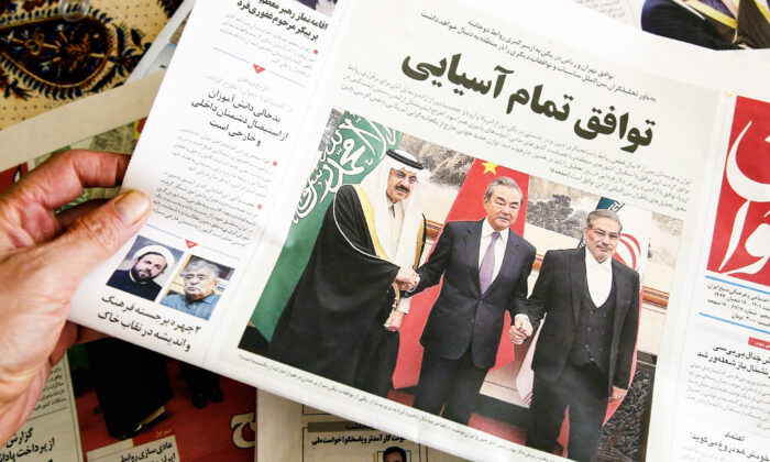 Một người cầm tờ báo địa phương đưa tin về thỏa thuận khôi phục quan hệ giữa Iran và Saudi Arabia do Trung Quốc làm trung gian, tại thủ đô Tehran của Iran hôm 11/03/2023. (Ảnh: Atta Kenare/AFP qua Getty Images)