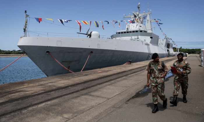 Các binh sĩ của Lực lượng Phòng vệ Quốc gia Nam Phi (SANDF) đi ngang qua khu trục hạm quân sự Nam Phi “SAS Mendi” cập cảng ở Richards Bay hôm 22/02/2023. Nam Phi bắt đầu cuộc tập trận quân sự chung kéo dài 10 ngày bắt đầu từ ngày 17/02/2023 với Nga và Trung Quốc. Những cuộc tập trận gây tranh cãi này, được đặt tên là “Mosi” có nghĩa là “khói” trong ngôn ngữ Tswana địa phương, đang diễn ra ngoài khơi hai thành phố cảng Durban và Richards Bay. (Ảnh:Guillem Sartorio/AFP qua Getty Images)