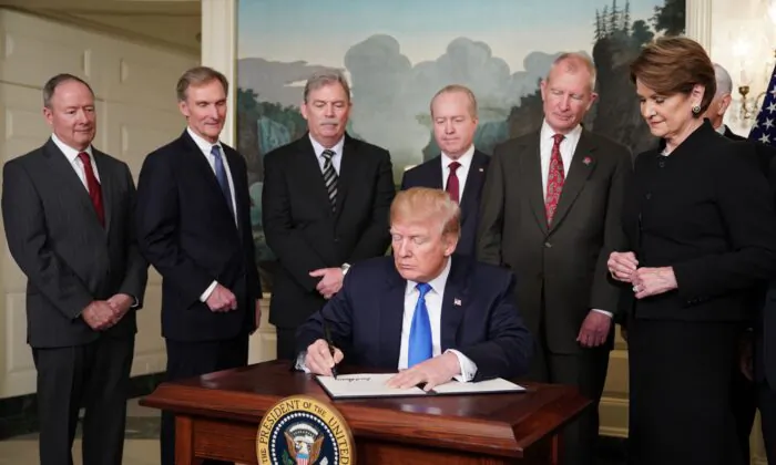 Tổng thống Hoa Kỳ đương thời Donald Trump ký các biện pháp trừng phạt thương mại đối với Trung Quốc tại Phòng Khánh tiết Ngoại giao của Tòa Bạch Ốc ở Hoa Thịnh Đốn, vào ngày 22/03/2018. (Ảnh: Mandel Ngan/AFP qua Getty Images)