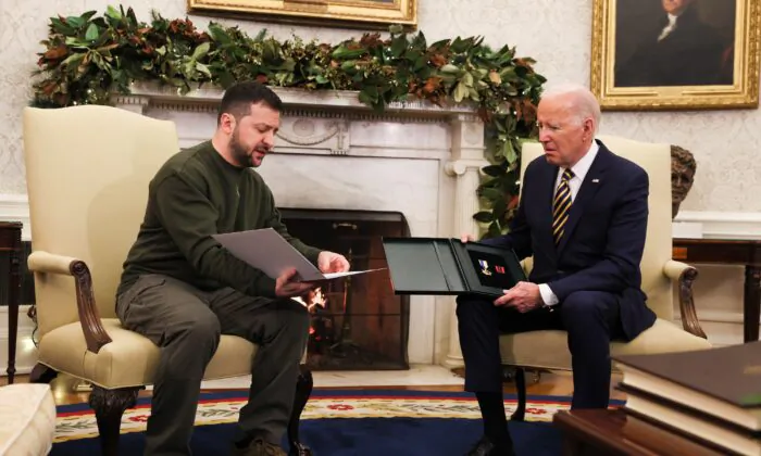 Tổng thống Ukraine Volodymyr Zelensky (bên trái) trao món quà của một quân nhân cho Tổng thống Hoa Kỳ Joe Biden tại Oval Office ở Tòa Bạch Ốc vào ngày 21/12/2022. (Ảnh: Leah Millis/Reuters)