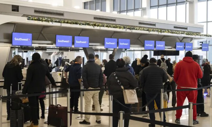 Những hành khách xếp hàng chờ làm thủ tục để lên chuyến bay của họ tại quầy dịch vụ của hãng hàng không Southwest Airlines tại Phi trường LaGuardia ở New York, vào ngày 27/12/2022. (Ảnh: Yuki Iwamura/AP Photo)