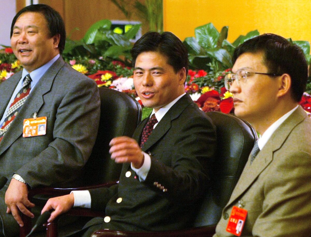 Doanh nhân kiêm Đảng viên Đảng Cộng sản Tưởng Tích Bồi (Jiang Xipei) (Giữa) được ngồi cạnh ông Tảm Thánh Đạt (Phải), xếp thứ 39 trong danh sách 100 người giàu nhất Trung Quốc của Forbes, và ông Thẩm Văn Vinh, xếp thứ 39 trong danh sách của Forbes, tại một cuộc họp báo tại Đại hội Đảng Cộng sản lần thứ 16 ở Bắc Kinh vào ngày 11/11/2002. (Ảnh: Peter Parks/AFP qua Getty Images)