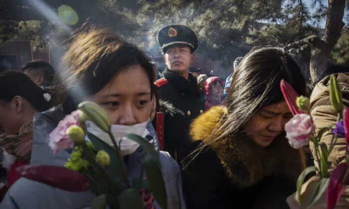 Một cảnh sát bán quân sự theo dõi những người thờ cúng Trung Quốc khi họ cầu khấn tại Ung Hòa Cung (hay còn gọi là Chùa Lạt Ma) ở Bắc Kinh, Trung Quốc, vào ngày 08/02/2016. (Ảnh: Kevin Frayer/Getty Images)